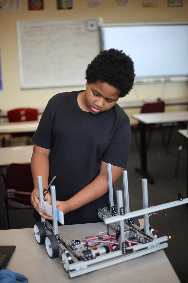 Student building a robot in class